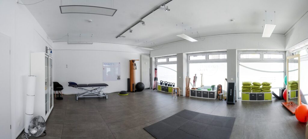 Heller Trainingsraum der Physiotherapiepraxis rundumfit in Krefeld mit Behandlungsliege und Trainingsgeräten