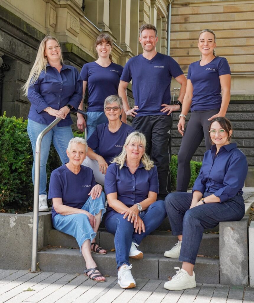 Das Team von rundumfit auf einer Treppe in der Krefelder Innenstadt